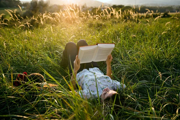 躺在草地上看书的女人 — 图库照片