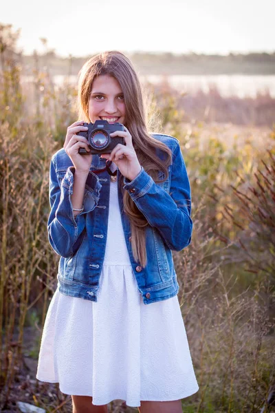 Meisje in witte jurk met fotocamera — Stockfoto