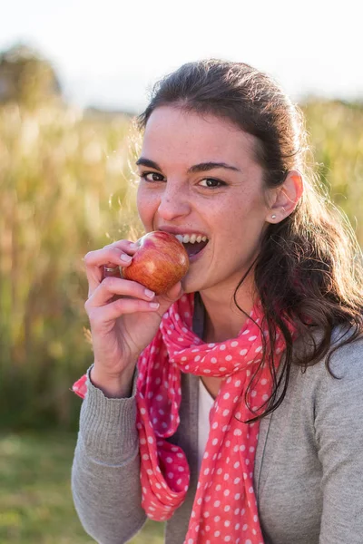 Girl biting red apple