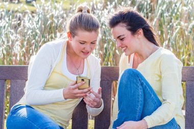 Söz, birlikte açık havada parkta bankta oturan vakit genç kadınlar.