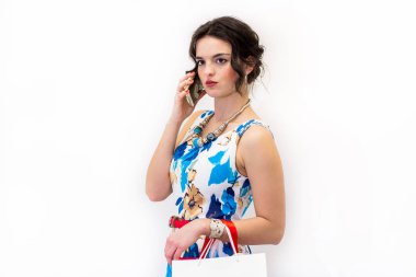 Cep telefonu üzerinde konuşurken parlak yazlık elbise esmer modeli ayakta.