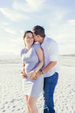 Mutlu hamile genç çift etkileşim ve eğleniyor, açık havada, ayakta, kucaklayan ile rahat kıyafet sahne, plaj.