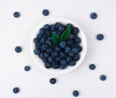 Taze yaban mersini beyaz bir kase aldı.