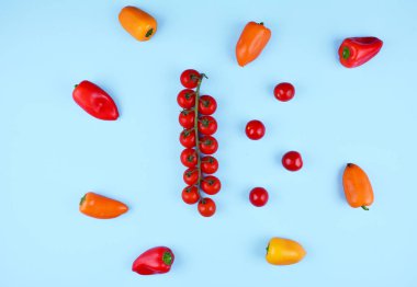 Kiraz domates ve mavi zemin üzerine kırmızı biber.