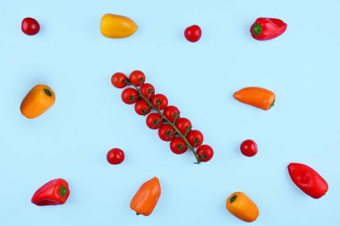 Kiraz domates ve mavi zemin üzerine kırmızı biber.