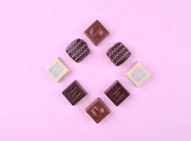 Pembe trendy zemin üzerine çeşitli çikolatalı pralin.