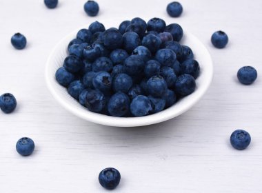 Taze yaban mersini beyaz bir kase aldı.