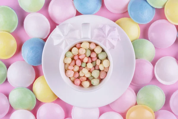 Pequenos doces de cor pastel em uma xícara branca . — Fotografia de Stock
