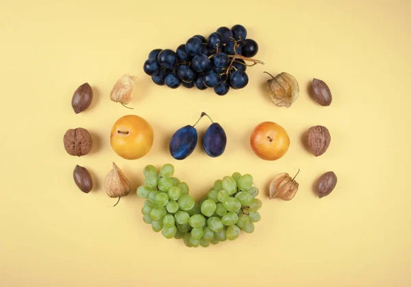 Herfst fruit en noten op gele achtergrond. — Stockfoto
