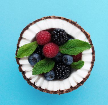 Çilek ile mavi arka plan üzerine Hindistan cevizi. 