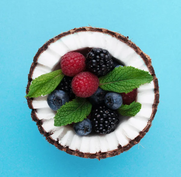 Çilek ile mavi arka plan üzerine Hindistan cevizi. 