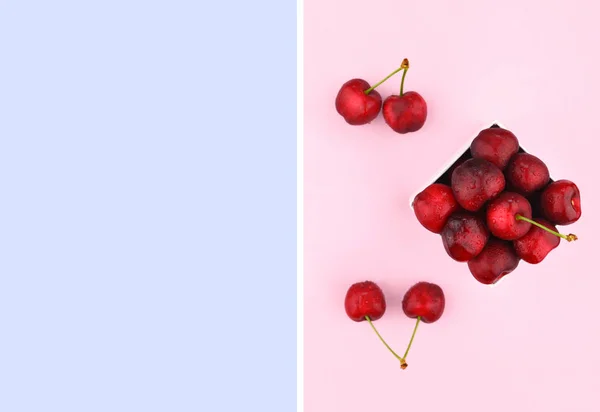 Cerejas maduras doces no fundo rosa . — Fotografia de Stock