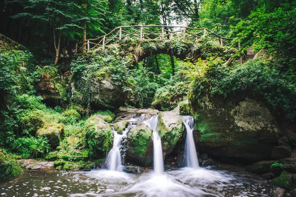 Bir şelale üzerinde taş köprü.