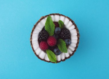 Çilek ile mavi arka plan üzerine Hindistan cevizi.