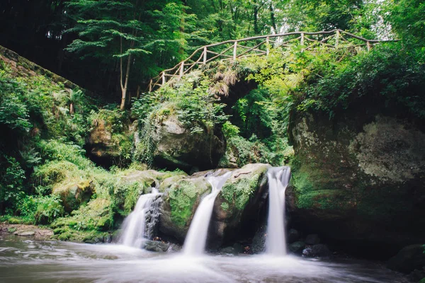Bir şelale üzerinde taş köprü.