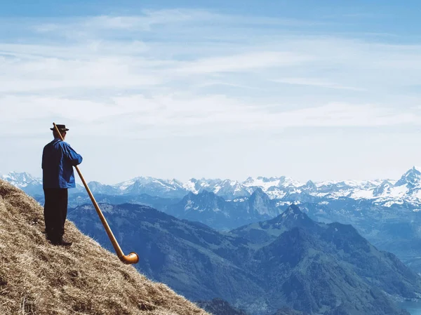 Musikern blåser alphorn. — Stockfoto