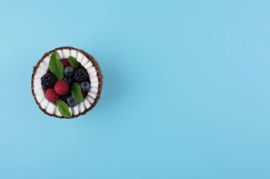 Çilek ile mavi arka plan üzerine Hindistan cevizi.