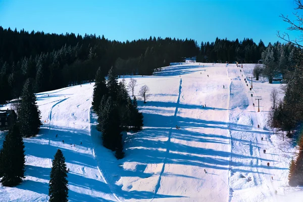 Skipisten auf schneebedeckter und sonniger Bergseite — Stockfoto