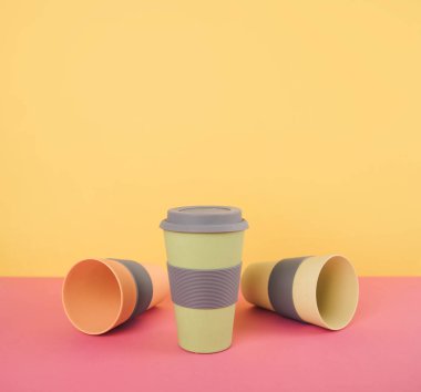 Renkli kağıt arka plan üzerinde kahve bardakları götürün.