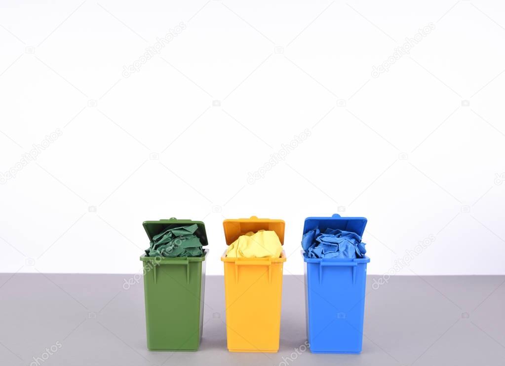 Colorful recycle bins on white background.