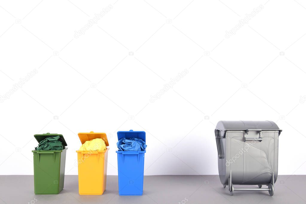 Colorful recycle bins on white background.