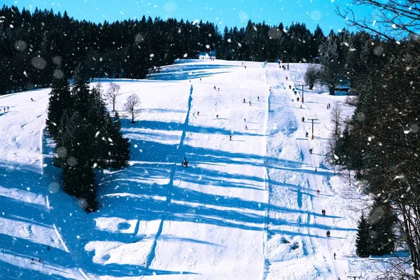 Skipisten auf schneebedeckter und sonniger Bergseite — Stockfoto