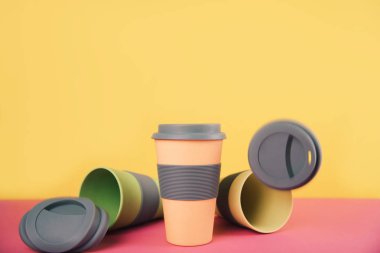 Renkli kağıt arka plan üzerinde kahve bardakları götürün.