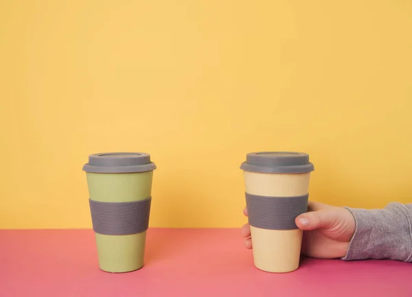 Take away coffee cups on colorful paper background.