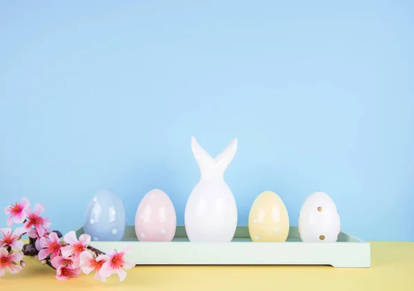 Пасхальная композиция с окрашенными яйцами и пасхальным кроликом — стоковое фото