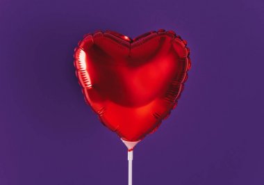 Ultra violet arka plan üzerinde kırmızı kalp balon.
