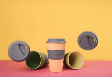 Renkli kağıt arka plan üzerinde kahve bardakları götürün.