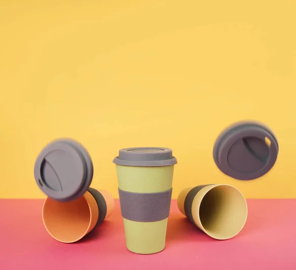 Llevar tazas de café sobre fondo de papel colorido . — Foto de Stock