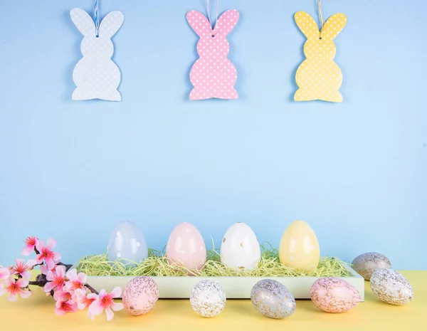 Creative easter composition with painted eggs and easter bunny. — Stock Photo, Image