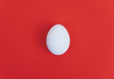 Kırmızı zemin üzerine beyaz bir yumurta.