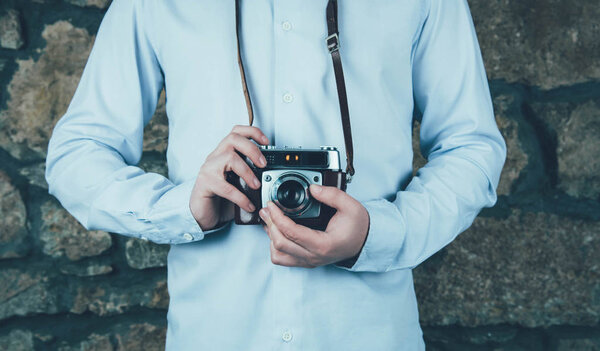 Hands holding retro camera.
