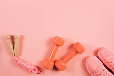 Spor ve fitness aletleri yaşayan mercan arka plan üzerinde yaratıcı düz lay.