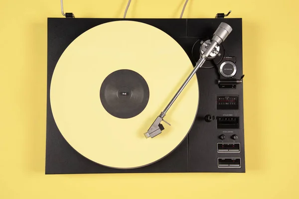 Gekleurde vinyl plaat op een gele achtergrond met kopieerruimte. Stockafbeelding