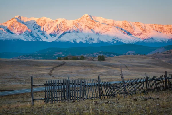 Wooden fence in snow covered mountains