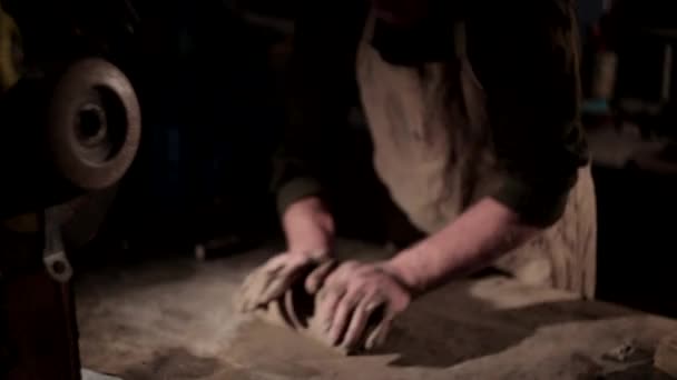 Дорослий чоловік-гончар готує глину на столі. Вид спереду, крупним планом, тільки руки, невпізнавані . — стокове відео