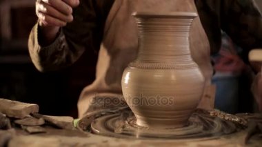 Potter bir dize potters tekerlek bir sürahi keser.