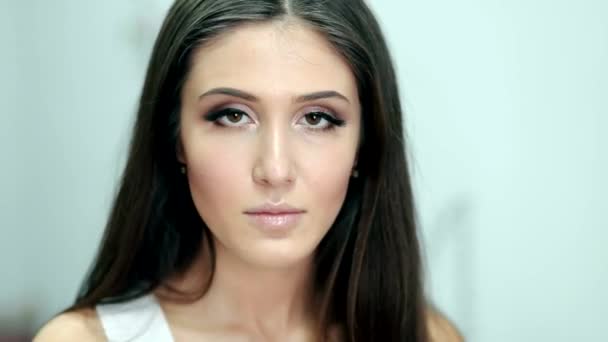Güzel kadın kameraya etkileyici hafif bir arka plan üzerinde seyir — Stok video