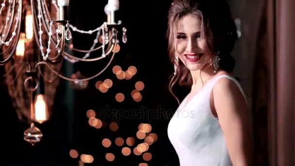 Feliz hermosa novia sexy chica morena mujer en vestido de novia blanco con peinado y maquillaje brillante en el interior — Vídeo de stock