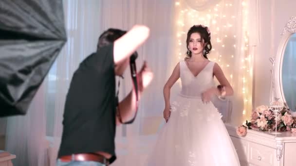 Fotograf fotografiert schöne Braut im Innenraum — Stockvideo
