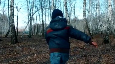 Ağır çekim steadicam atış yaz, parlak akşam BM arkasında parlayan kırsal yol boyunca bir çalışma olan küçük bir çocuk. Temiz hava etkinliği