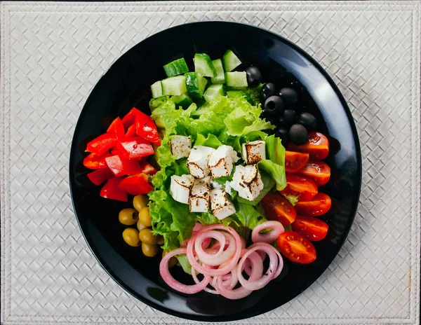 Ингредиенты для греческого салата на черной тарелке — стоковое фото