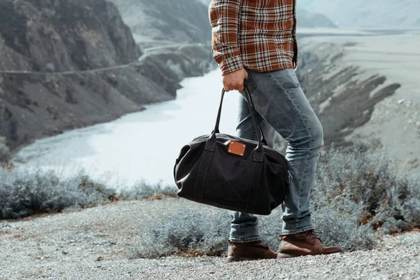 Hombre con bolsa en la mano caminando por un camino de montaña —  Fotos de Stock