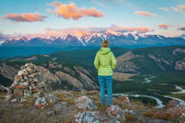 Güzel kız gündoğumu izlerken dağın zirvesinde
