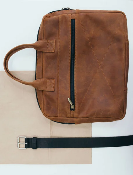Accesorios para hombre. El cinturón de cuero y una bolsa acostada en una mesa . — Foto de Stock