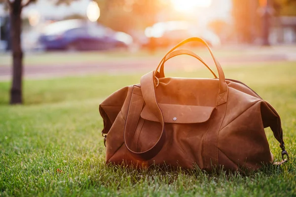 Zapatos marrones retro y bolso de cuero para hombre en hierba de verano de colores brillantes en el parque —  Fotos de Stock