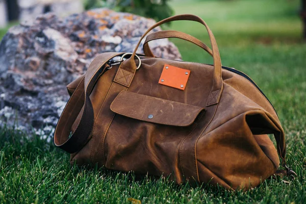 Retro kahverengi Ayakkabı ve erkek deri çanta parlak renkli yaz çim Park